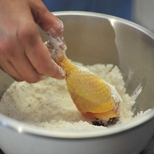 Mezclar la harina con la pimienta y sazonar con una cucharita de sal. Pasar las piezas de pollo.