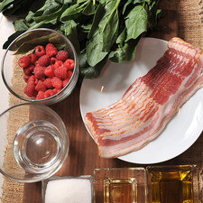 desinfectante de verduras al gusto 250 gramos de tocino 1/2 taza de agua 2 manojos de espinaca 6 cucharadas de azúcar blanca 1/4 taza de aceite de oliva extra virgen 2 cucharadas de vinagre de manzana 1 taza de frambuesas