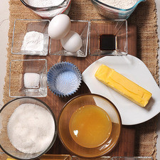 1 cucharita de polvo para hornear (levadura química) 1 3/4 tazas de harina de trigo 1 cucharada de ralladura de cáscara de naranja 12 piezas de capacillos para cupcake 3 cucharadas de jugo de naranja 3 cucharadas de mantequilla 1/8 cucharita de sal 1 1/2 tazas de azúcar glass (pulverizada) 1/2 taza de jugo de naranja 1 cucharita de extracto de vainilla 2 piezas de huevo 1 taza de azúcar blanca 90 gramos de mantequilla 1/2 cucharita de sal