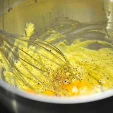Batir la mantequilla suavizada junto con el aceite de oliva utilizando un batidor de globo hasta acremar la mezcla. Agregar una cucharita de sal, pimienta recién molida y una pizca de nuez moscada. Agregar un huevo completo y una yema de huevo, continuar batiendo hasta integrar. Agregar el otro huevo y la otra yema, batir hasta integrar nuevamente. Añadir poco a poco cucharadas de la harina con polvo para hornear a la mezcla húmeda e integrar con una pala miserable, utilizando un movimiento envolvente.