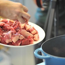 Cortar la ternera en cubos tamaño bocado. Calentar las cinco cucharadas de aceite de oliva en una cacerola gruesa, cuando comience a salir un poco de humo sellar la ternera.