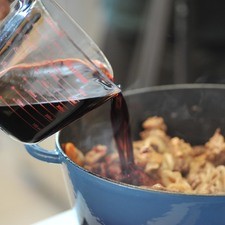 Agregar una y media tazas del vino, el ajo picado, el tomillo y el laurel. La carne debe estar cubierta de líquido, si hiciera falta, agregar agua. Tapar y continuar cociendo a fuego muy bajito durante dos horas o dos horas y media, mezclando de vez en cuando y agregando agua si fuera necesario. La carne lista cuando se parte fácilmente con el tenedor.