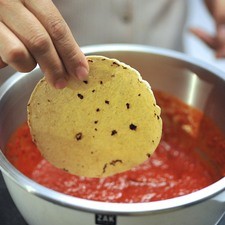 Calentar un poco de aceite en una sartén abierta. Sumergir las tortillas una por una en la salsa de chile.