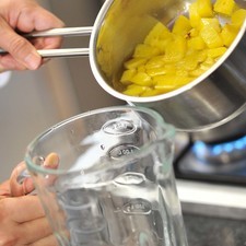 Colocar la piña con el almíbar en el vaso de la licuadora, moler sólo unos segundos para que queden trozos enteros de piña.