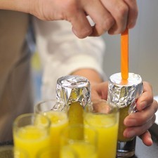 Ponerles una cubierta de papel aluminio. Perforar el aluminio para colocar los palos de paleta en el centro del vaso. Meter los vasos al congelador al menos tres horas. Para sacar las paletas de los vasos, introducir unos segundos en agua tibia para poder desmoldar.