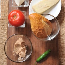 Ingredientes para los molletes 1 pieza de pan bolillo 50 gramos de queso chihuahua 1/2 taza de frijoles refritos Ingredientes para la salsa 1/2 pieza de chile serrano 1/8 pieza de cebolla blanca 1 pieza de jitomate bola sal al gusto