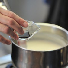Disolver la maicena en un poco de agua. Agregar a la leche caliente y mezclar vigorosamente para que no se formen grumos. Continuar cociendo unos cinco minutos más sin dejar de mover hasta que se espese. Retirar la rama de canela con una pinza. Agregar la vainilla y mezclar.