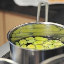 Poner a cocer las habas previamente peladas en una olla con agua hasta que se tornen suaves, aproximadamente 10 minutos.
