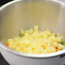 Mezclar las habas, las zanahorias y las papas cocidas y frías en un tazón.
