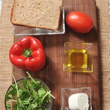 Ingredientes para toda la receta: 4 rebanadas de pan integral 1 pieza de pimiento morrón rojo 2 cucharadas de aceite de oliva 50 gramos de queso de cabra 1 pieza de jitomate guaje 1 taza de arúgula