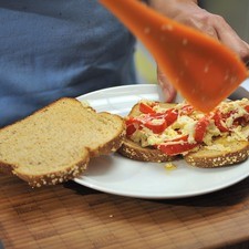 Untar el queso con pimientos en una rebanadas de pan.