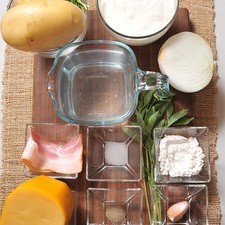 3 rebanadas de tocino 1/2 pieza de cebolla blanca 1 diente de ajo 3 cucharadas de harina de trigo 2 piezas de papa blanca 2 ramas de albahaca fresca 1/2 cucharita de sal 1/2 cucharita de pimienta negra molida salsa tabasco al gusto 8 ramas de cebollín 3 tazas de caldo de pollo 1 taza de crema de leche de vaca 1/4 taza de queso gouda