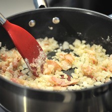 Agregar la cebolla y el ajo picados y acitronar un par de minutos hasta que se vea translúcida. Añadir la harina y mezclar bien. Continuar cociendo un minuto más.