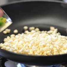 Para preparar las verduras, calentar una cucharada de aceite en una sartén a fuego medio. Agregar el elote desgranado.