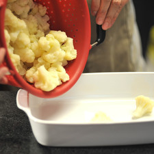 Colocar la coliflor en un recipiente para horno.