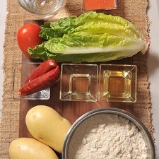 Ingredientes para el relleno: 2 piezas de papa blanca 100 gramos de chorizo 1 cucharada de aceite de canola Ingredientes para la masa: 4 tazas de harina de maíz 1/4 cucharita de sal aceite de canola al gusto agua tibia al gusto Ingredientes para acompañar: 1/4 pieza de lechuga 1 pieza de jitomate guaje salsa picante al gusto