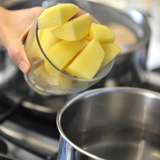 Precalentar el horno a 200°C. Hervir agua en una cacerola pequeña, cocer las papas medianas, peladas y en cubos durante 7 minutos, hasta que estén casi cocidas.