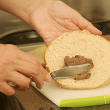Cortar los bagels a la mitad. Untar con frijoles refritos.