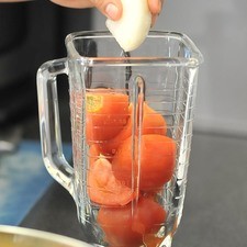 Para preparar la salsa, moler el jitomate con el diente de ajo y el trozo de cebolla en la licuadora.