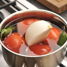Hervir los jitomates junto con los chiles serranos, un cuarto de la cebolla y el diente de ajo durante aproximadamente 5 minutos hasta que cambien de color, es importante que la cáscara no se abra para que no se tornen ácidos.