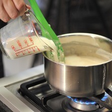 Cuando comience a espesar agregar la leche y el azúcar. Mezclar continuamente en una misma dirección hasta que tome consistencia de atole espeso.