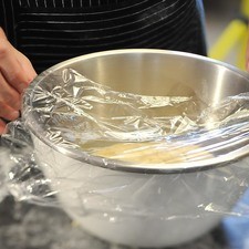 Colocar la bola de masa dentro del tazón y cubrir con papel plástico para sellar bien. Dejar reposar a temperatura ambiente en un lugar cálido durante aproximadamente una hora hasta que la masa doble su tamaño. Nota: una vez esponjada la masa se puede ponchar, volver a tapar y refrigerar durante una noche. S 6726 1475624065