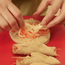 Pelar la zanahoria y rallarla. Desmenuzar el queso Oaxaca. Poner un poco de zanahoria y queso en cada tortilla, aproximadamente la misma cantidad de cada una. Enrollar. Estos tacos se pueden congelar así crudos hasta una semana si no se van a consumir todos.