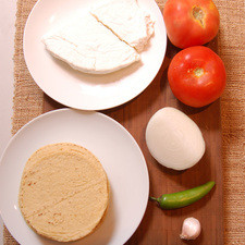 Ingredientes para la salsa 2 piezas de jitomate bola sal al gusto 1 cucharada de aceite de oliva 1 diente de ajo Ingredientes para el relleno 1/4 pieza de cebolla blanca 1 pieza de chile serrano 250 gramos de queso doble crema Ingredientes para las enchiladas 12 piezas de tortilla de maíz