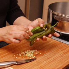 Hacer un corte por un lado de cada chile con un cuchillo para retirar las semillas y las venas.