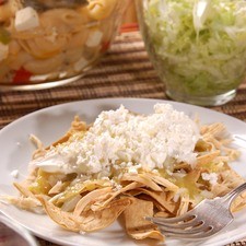 Servir tortillas tostadas en cada plato, agregar el pollo desmenuzado, bañar con salsa de tomatillo verde y aderezar con cebolla picada, crema y queso desmenuzado.