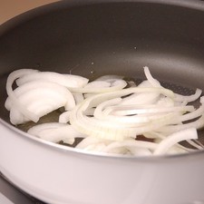 Partir la cebolla en rodajas y acitronar con aceite de oliva en el sartén hondo.