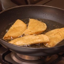 Pasar las tortillas un sartén con aceite a fuego medio, doblar por la mitad con una pala y continuar cociendo hasta que se doren.