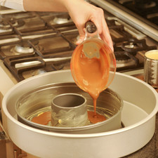 Engrasar bien el molde desmoldable para pastel mediano con mantequilla, incluyendo las paredes y después verter la taza de cajeta.