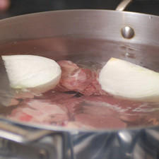 En una olla honda añadir la carne de cerdo cortada en trozos tamaño bocado con los trozos de cebolla y sazonar con sal. Mantener a fuego bajo hasta que la carne esté tierna, aproximadamente una hora.