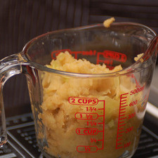 Colocar el bagazo de las manzanas en una taza medidora.