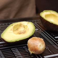 Para preparar el guacamole, cortar el aguacate por la mitad, retirar la semilla con ayuda de un cuchillo.