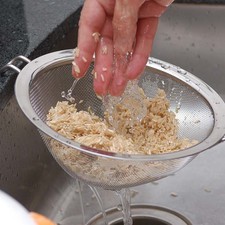 Colocar el arroz en un colador y enjuagar bajo el chorro de agua durante un minuto, mezclando con la mano.