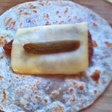 Coloca encima los frijoles, una rebanada de queso y chile en escabeche.