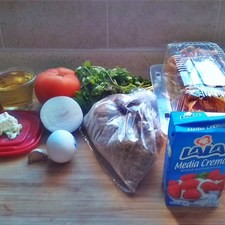 Necesitas: totopos o tiras de tortilla, machacado, tomáte, cilantro, cebolla, ajo, chile, sal, aceite, huevo, crema y queso fresco.