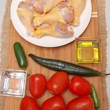 1/4 taza de agua 6 piezas de jitomate guaje aceite de oliva al gusto pimienta negra molida al gusto sal al gusto 2 piezas de chile serrano 1 pieza de chile jalapeño 1 pieza de chile chilaca 6 piezas de pollo