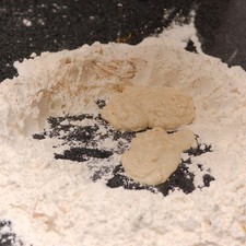 Sobre la mesa, colocar la harina restante y mezclar con la ralladura de naranja. Formar un volcán que tenga el centro grande y las paredes no muy altas.