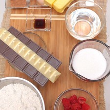 Ingredientes para los cupcakes 170 gramos de mantequilla 1 1/4 tazas de agua 1 1/4 tazas de azúcar blanca 2 3/4 tazas de harina de trigo 3 cucharadas de cocoa en polvo 2 piezas de huevo 1 1/4 cucharitas de extracto de vainilla 150 gramos de chocolate semi amargo para repostería 1/2 cucharita de polvo para hornear (levadura química) Ingredientes para el relleno 20 piezas de frambuesas 60 gramos de chocolate blanco para repostería