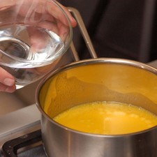 Derretir la mantequilla en una olla pequeña. Agregar el agua y calentar batiendo con el globo hasta emulsionar. Retirar del fuego.