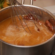 Añadir el chocolate semi-amargo en trozos y el azúcar. Batir con el globo hasta que el chocolate se derrita.