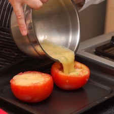 Colocar las mitades de jitomate en una charola para horno. Rellenar con los huevos batidos. Hornear durante 20 minutos hasta que los huevos estén cocidos.