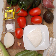250 gramos de lomo de puerco 6 tazas de agua 4 piezas de calabacita 1 diente de ajo aceite de oliva al gusto sal de mar al gusto 1 pieza de bolsa de plástico 100 gramos de queso fresco 1 pieza de aguacate 1 pieza de elote 1/4 pieza de cebolla blanca 5 piezas de jitomate guaje 4 piezas de chile poblano