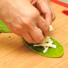 Colocar sobre una penca de nopal un poco de queso Oaxaca deshebrado.