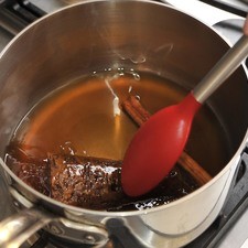 En una olla honda, poner a disolver el piloncillo en el agua, junto con la raja de canela y dejarlo hervir durante 5 a 10 minutos hasta que se forme una miel espesa. Remover la raja de canela.