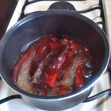 Mientras tanto, corta los chiles guajillo, retira las semillas y las venas y cuécelos en un poco de agua. Después, licúalos con un poco de agua limpia y un diente de ajo.