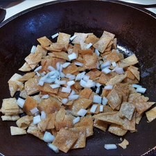 Corta las tortillas en cuadros, vierte aceite en un sartén y fríe ligeramente las tortillas no deben quedar tostadas, agrega la cebolla picada, espera a que se acitrone ligeramente S 7628 1475622133